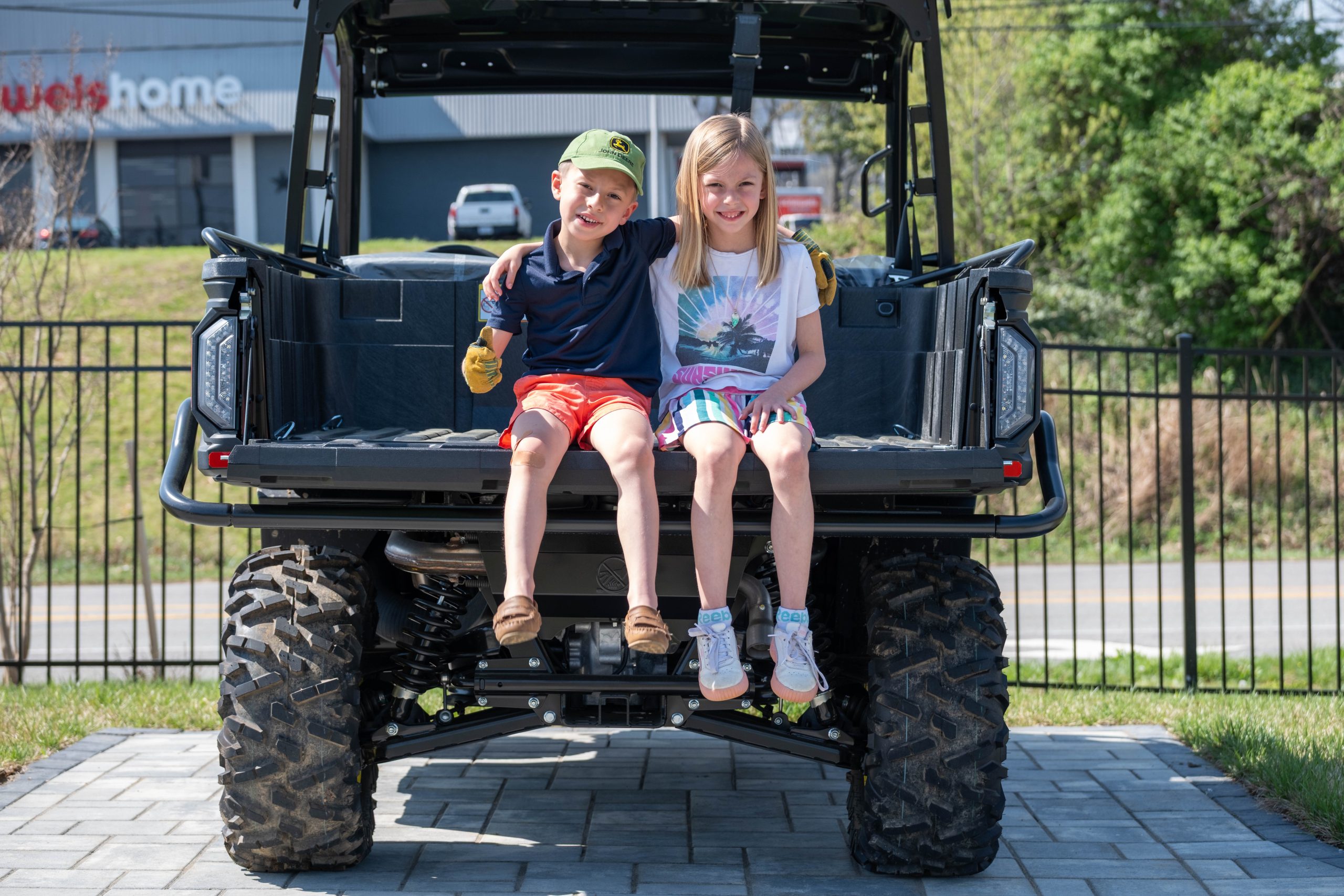 two children sitting on a UTV tailgate